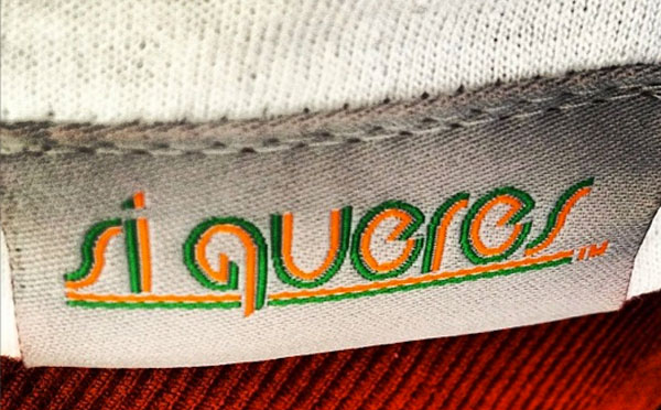 Si Queres logo on a shirt tag